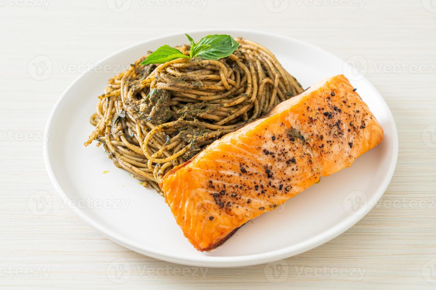 Homemade pesto spaghetti pasta with grilled salmon - Italian food style photo