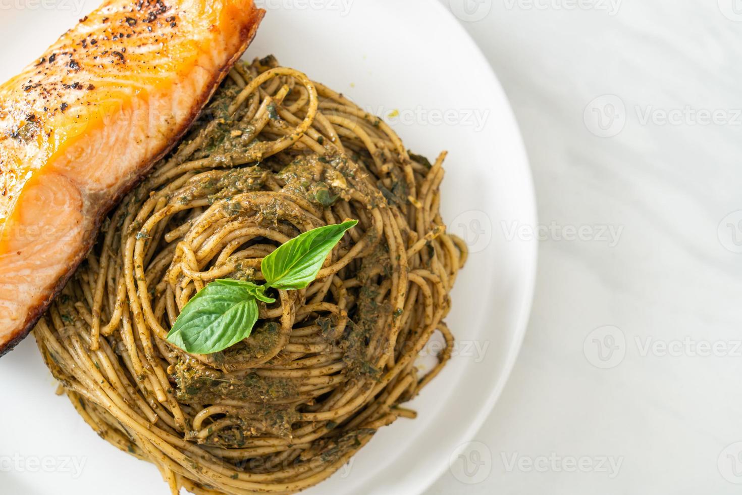 Homemade pesto spaghetti pasta with grilled salmon - Italian food style photo