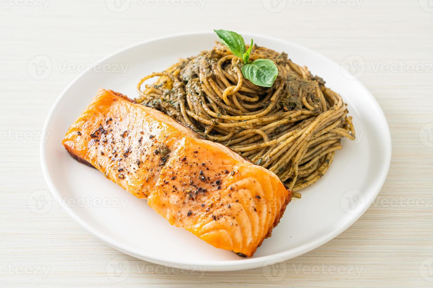 Homemade pesto spaghetti pasta with grilled salmon - Italian food style photo