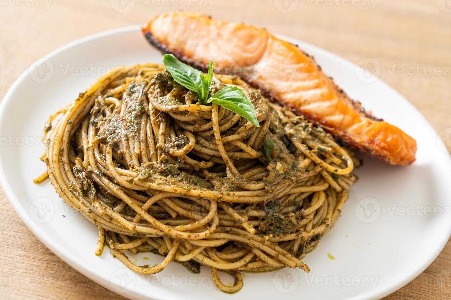 Homemade pesto spaghetti pasta with grilled salmon - Italian food style photo