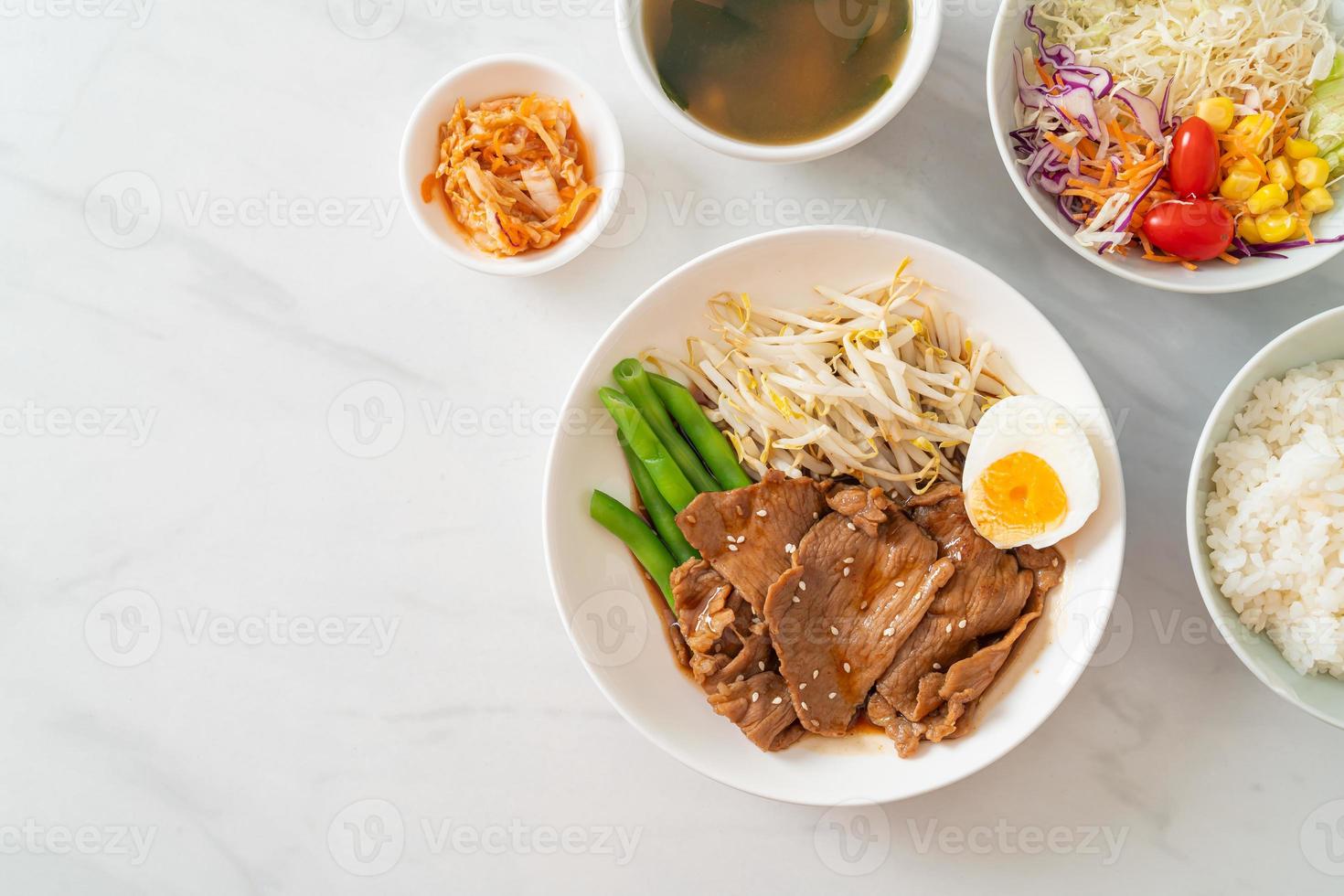 salteado de cerdo teriyaki con semillas de sésamo, brotes de frijol mungo, huevo cocido y juego de arroz - estilo de comida japonesa foto