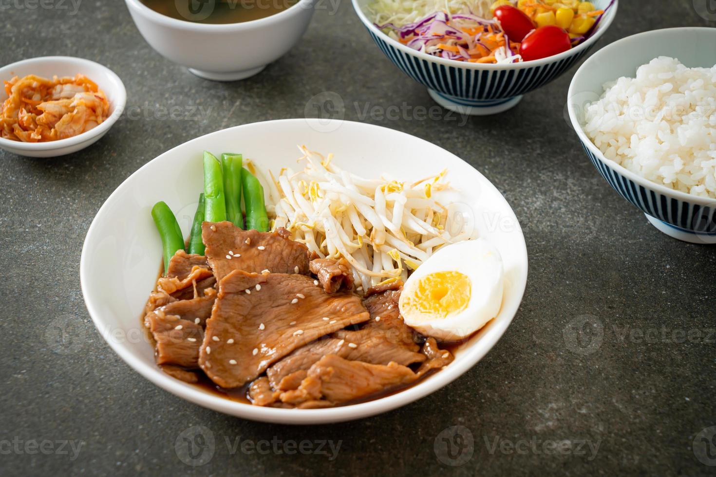 salteado de cerdo teriyaki con semillas de sésamo, brotes de frijol mungo, huevo cocido y juego de arroz - estilo de comida japonesa foto