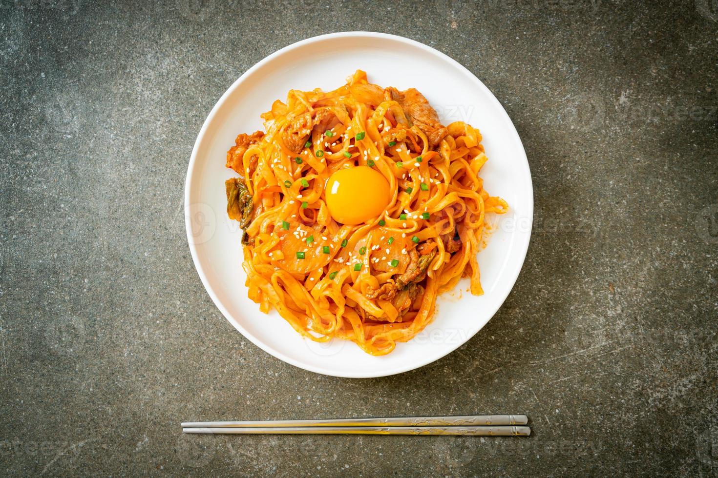 Stir-fried udon noodles with kimchi and pork - Korean food style photo