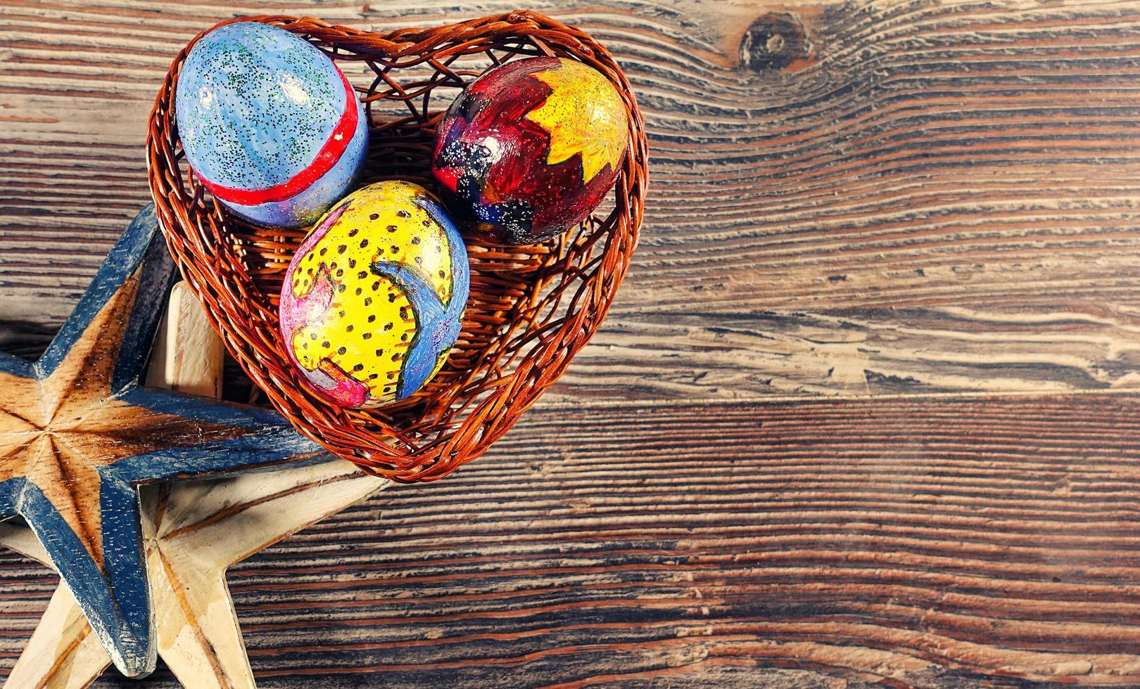 huevos de pascua en una canasta de corazón y estrellas de mar foto