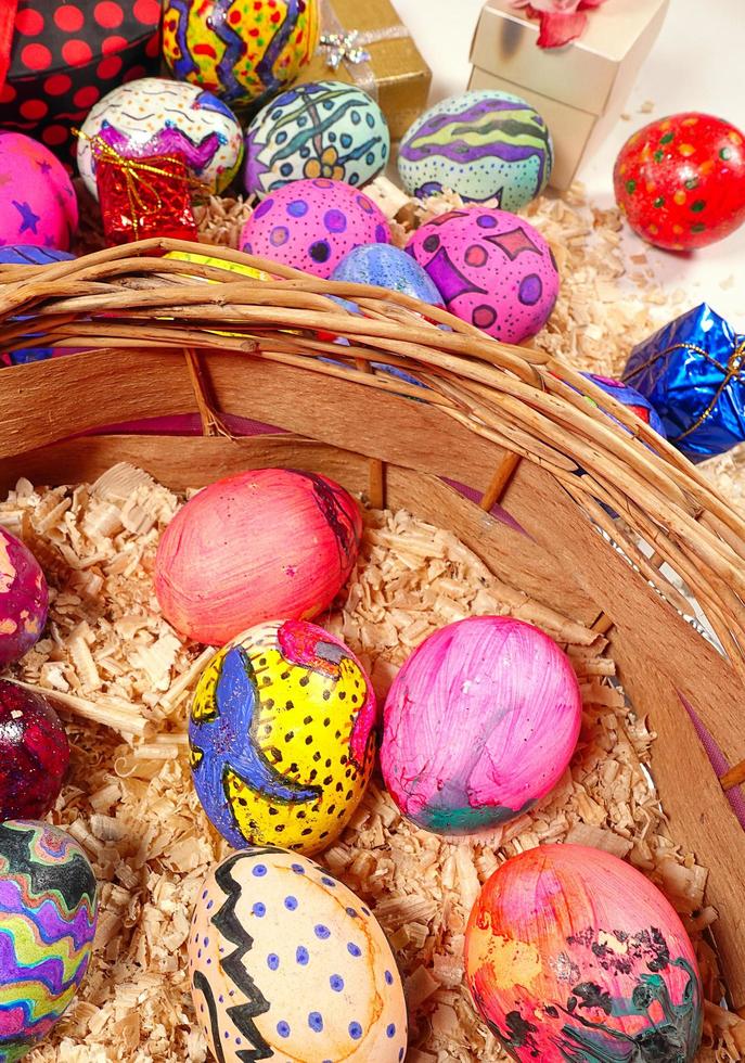 coloridos huevos de pascua en una canasta de madera foto