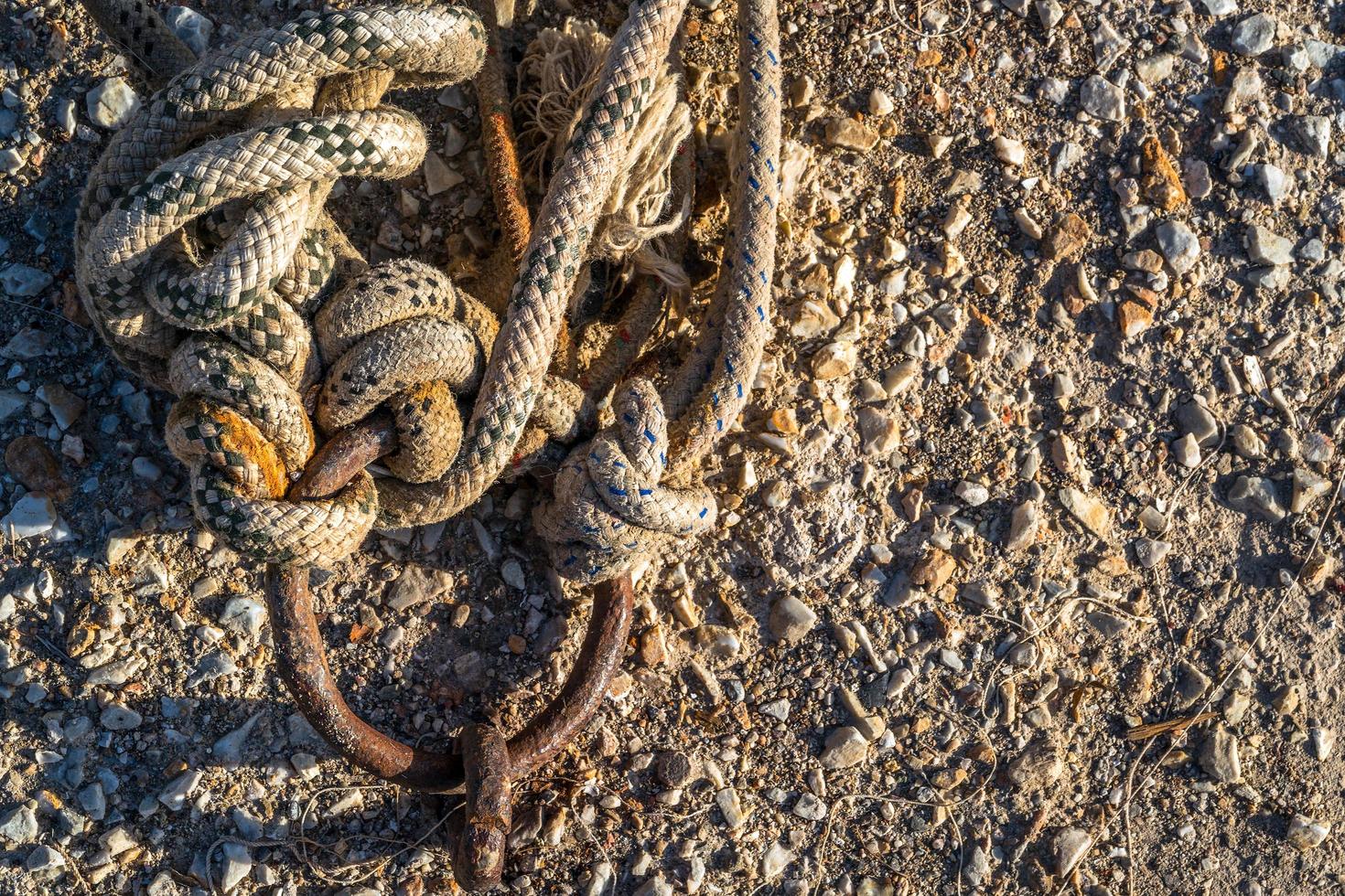 Cadena oxidada y cuerda cerca del muelle foto