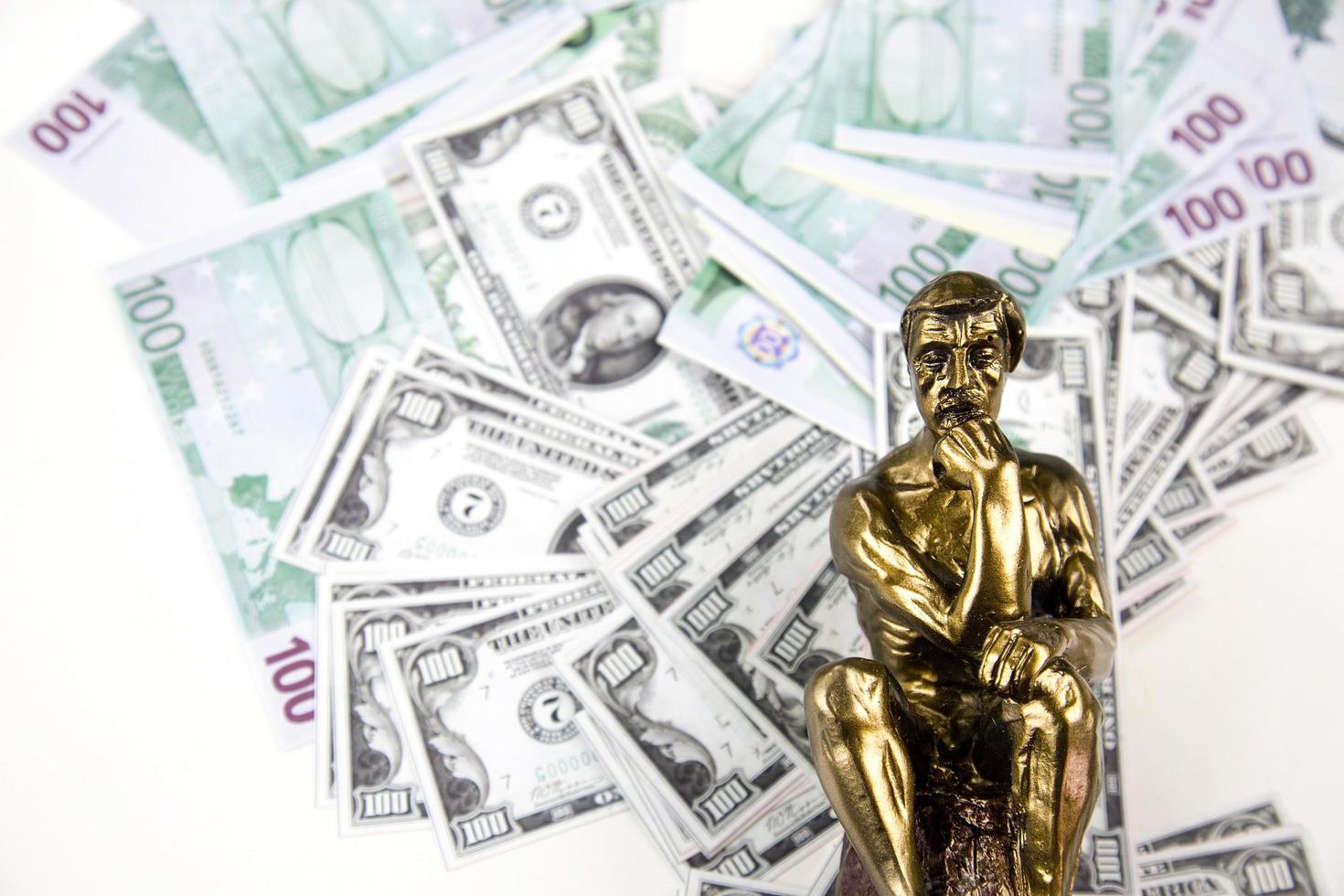 dinero en efectivo finanzas y pensamiento hombre musculoso estatua foto