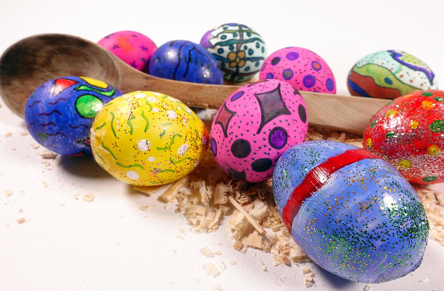 coloridos huevos de pascua pascual y celebración de cuchara de madera foto