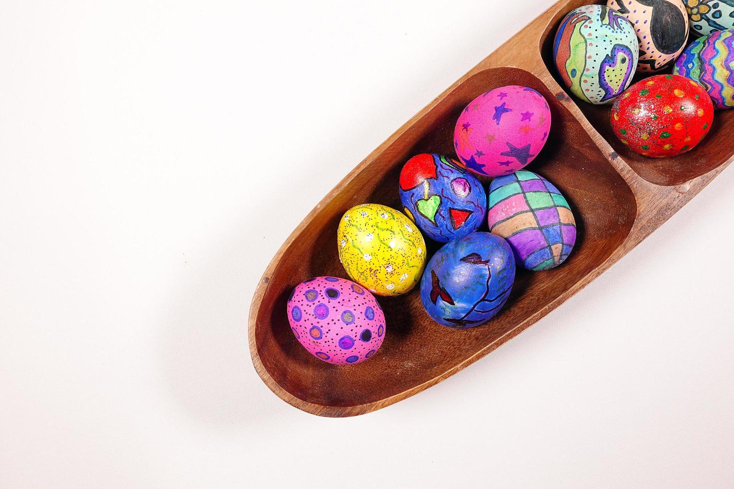 Huevos de Pascua coloridos pascuales en una placa de madera foto