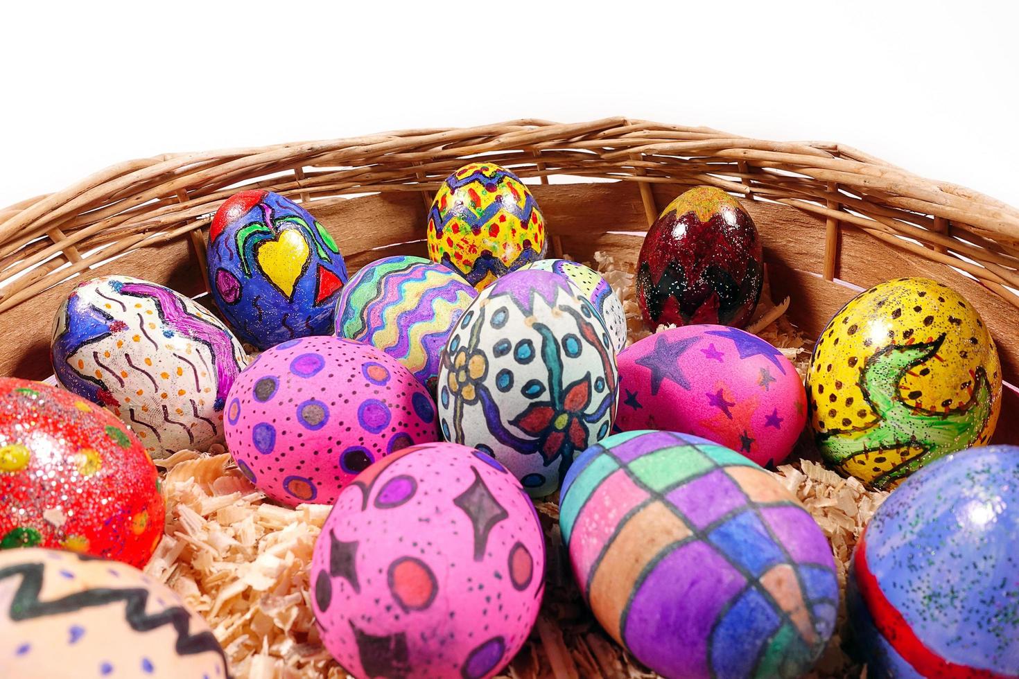 coloridos huevos de pascua en una canasta de madera foto