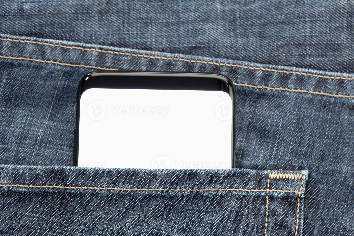 Close up of a smartphone in jeans pocket with white blank screen photo