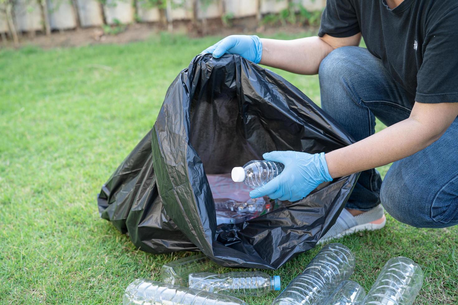 mujer asiática voluntaria llevar botellas de plástico de agua foto