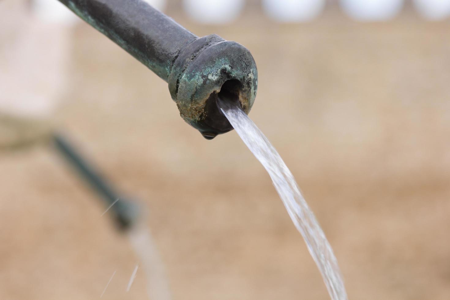 water coming out of an iron fountain photo