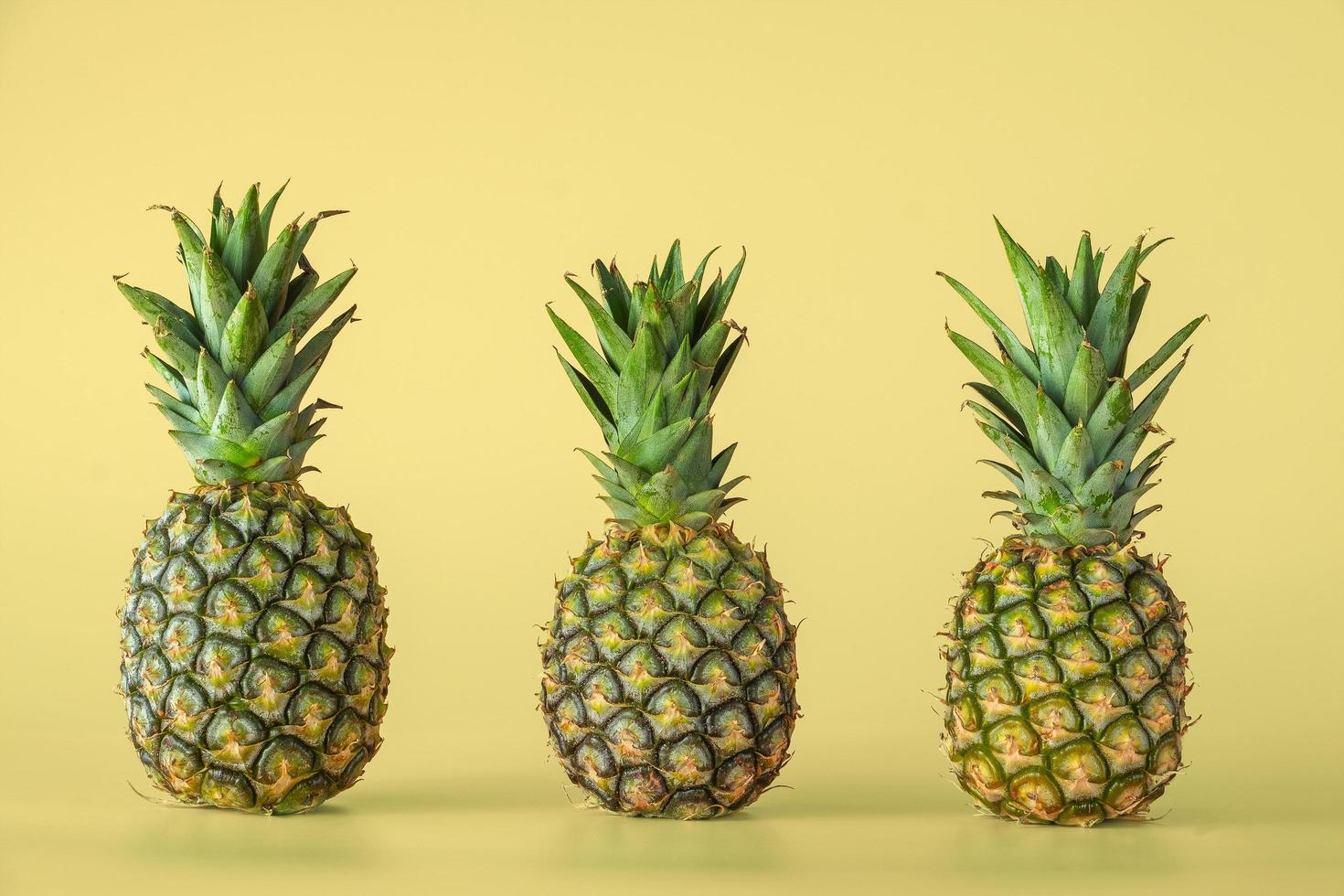 Pineapple fruit isolated on yellow background. photo