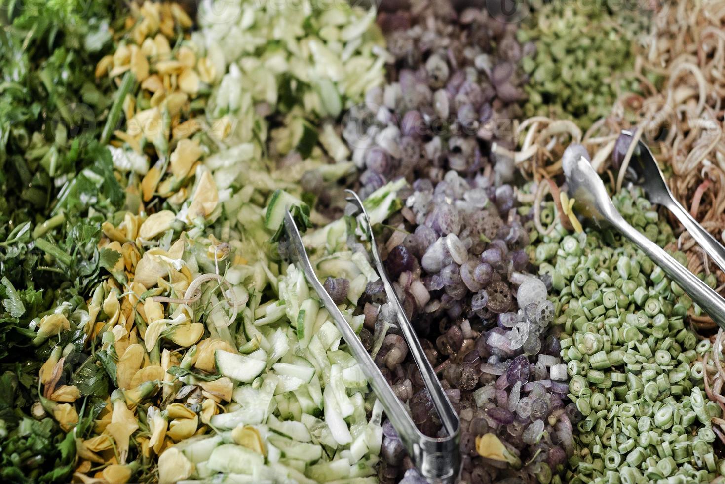 Mezcla de verduras camboyanas en el restaurante tradicional mesa buffet en Siem Reap con flor de plátano triturado en primer plano foto