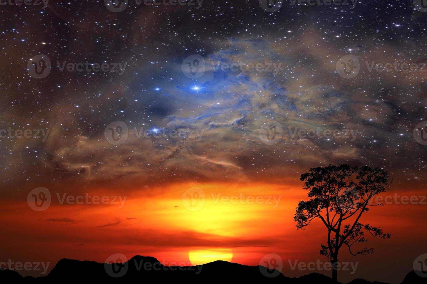 Half sun with red clouds over mountain with nebula photo