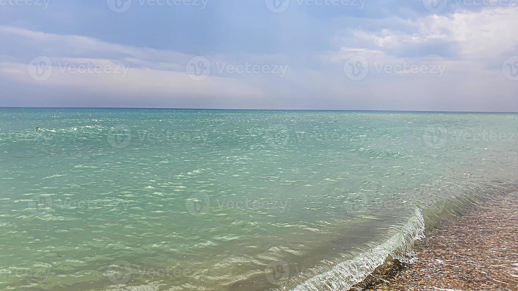 marina. color azul celeste del agua, olas espumosas en la orilla. foto