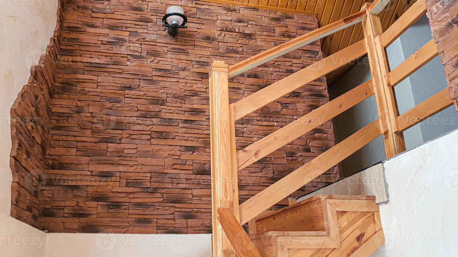 Interior items. Wooden staircase, lamp on the wall. photo