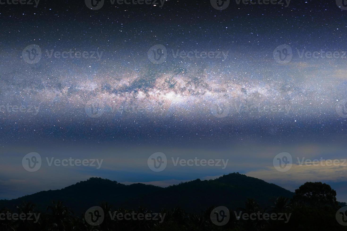 luz del paisaje nocturno de la vía láctea sobre la montaña silueta foto