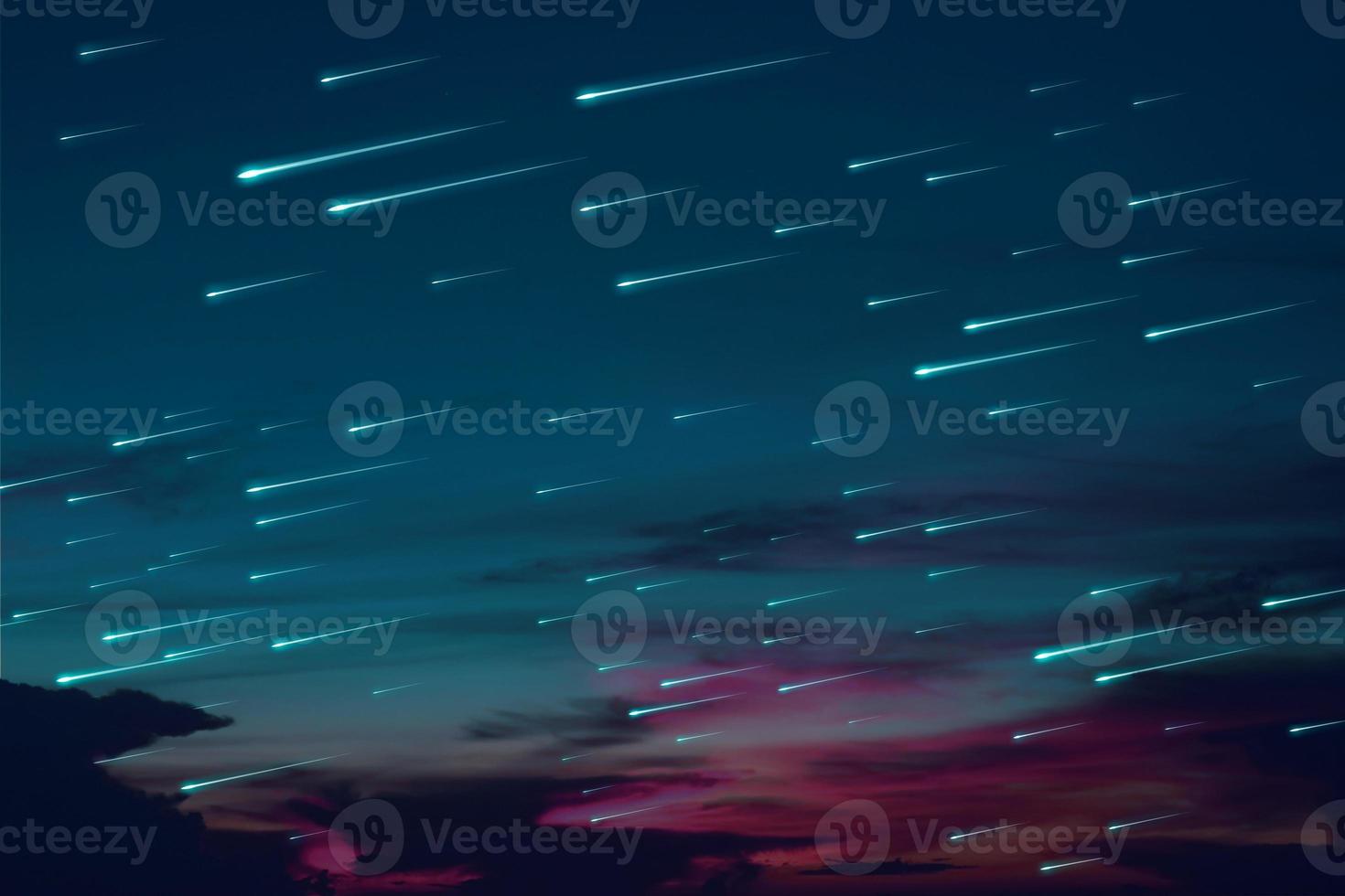 Blue meteors raining on sunset sky background photo