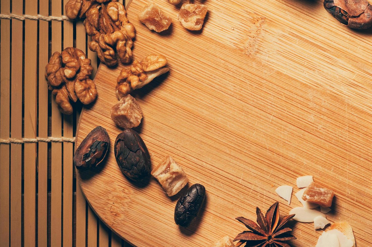 Nuts, fruit, cocoa beans and anise on acutting board photo