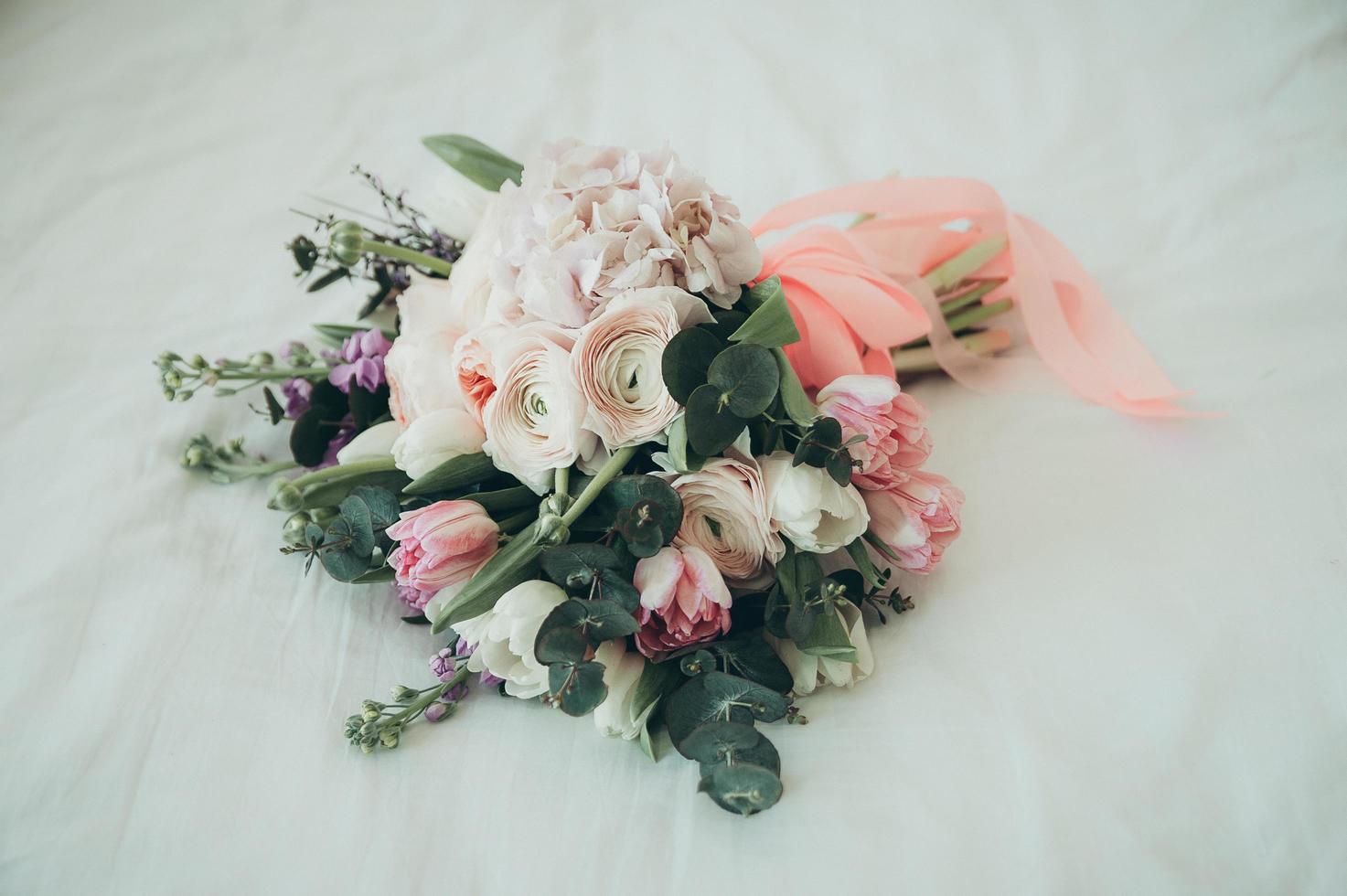 A bridal bouquet on a bed photo