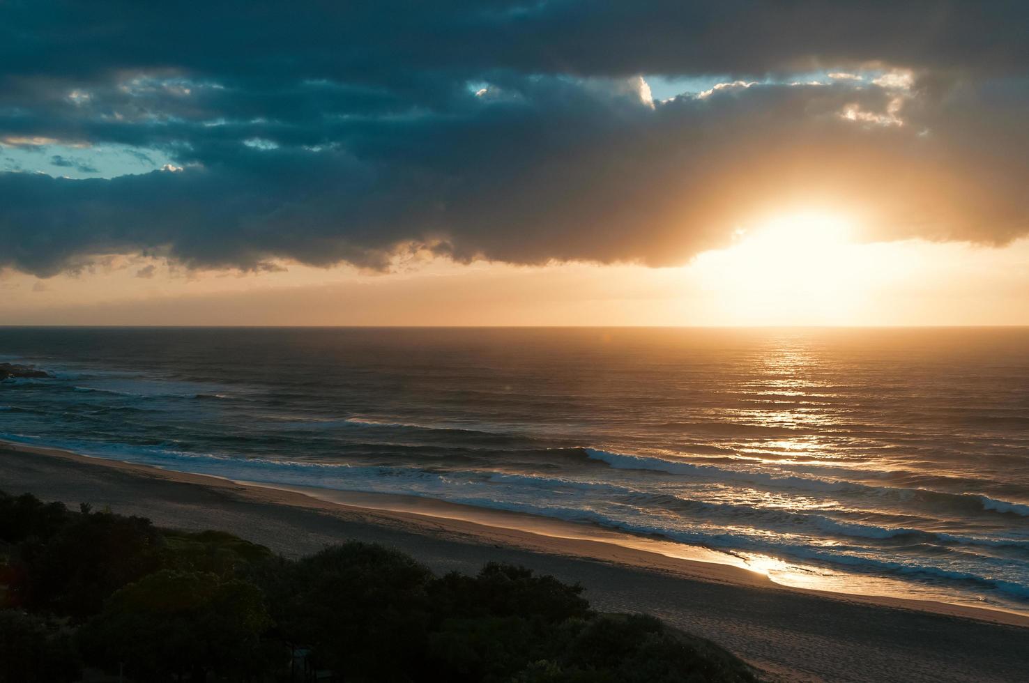 Early sunrise at the ocean beach, dramatic clouds over the horizon photo