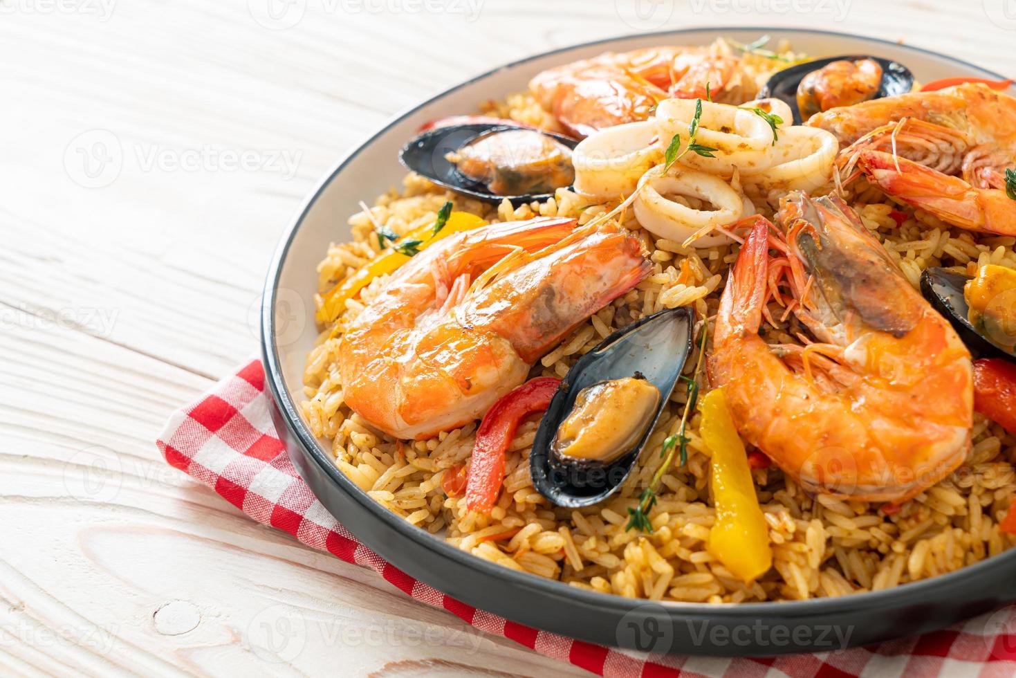 paella de marisco con gambas, almejas, mejillones sobre arroz con azafrán foto