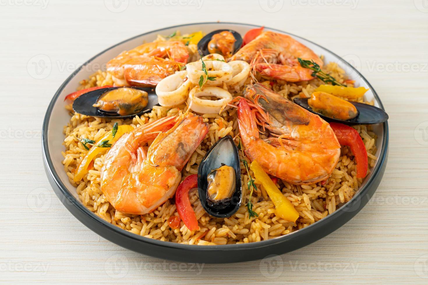 paella de marisco con gambas, almejas, mejillones sobre arroz con azafrán foto