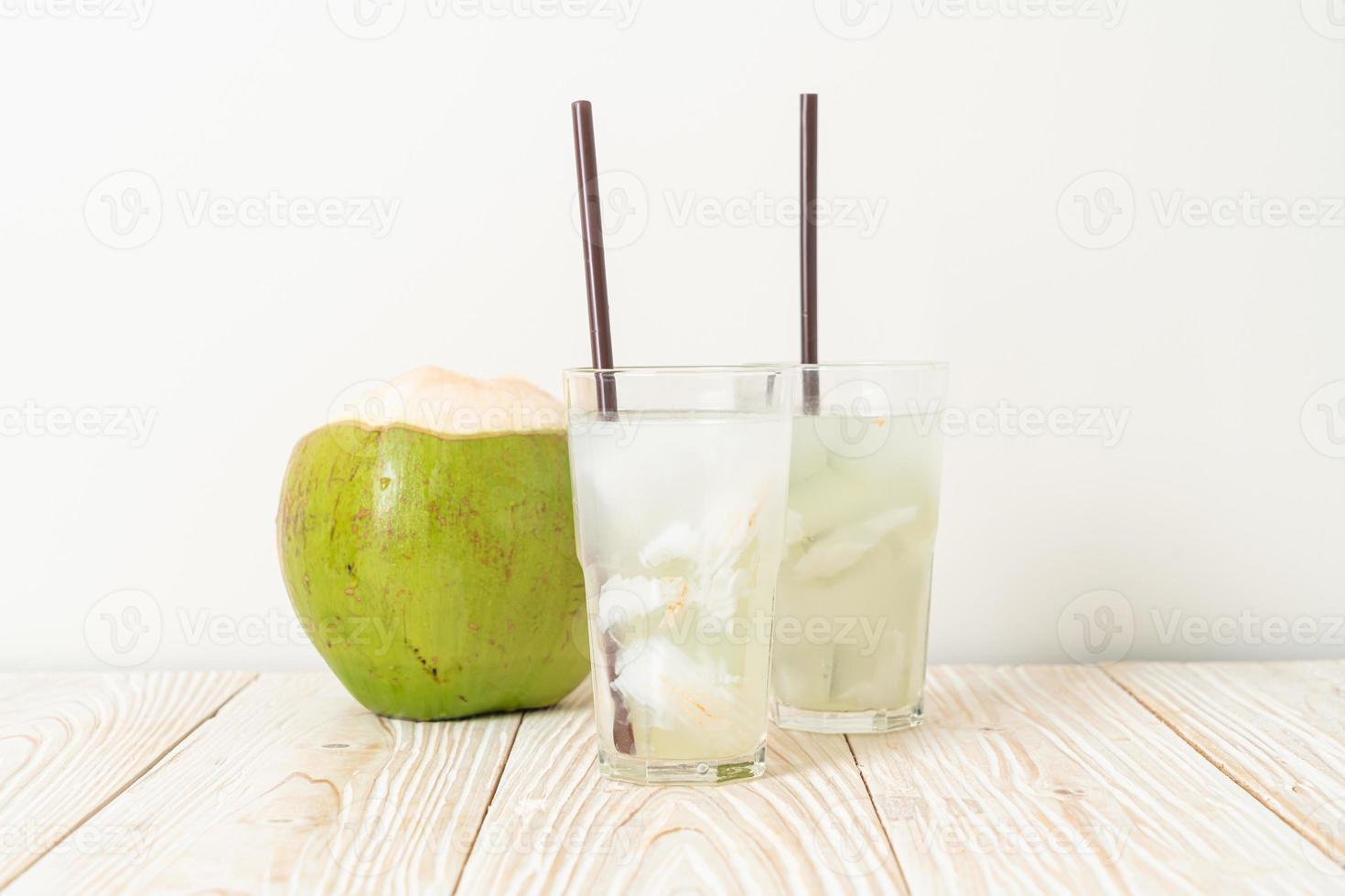 Coconut water or coconut juice in glass with ice cube photo