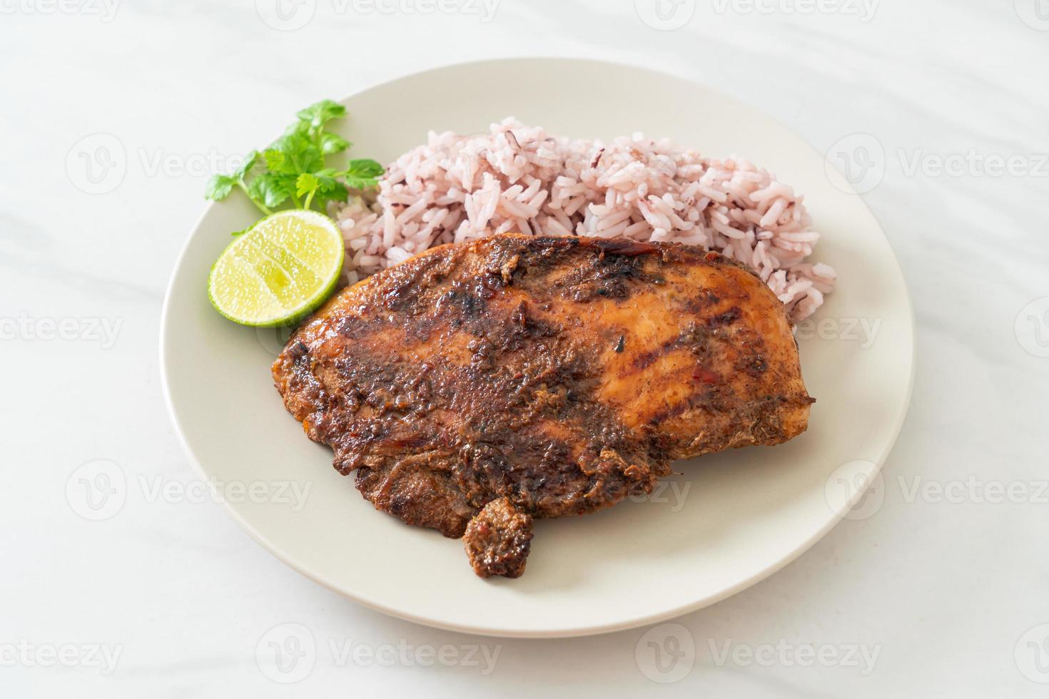 Pollo Jerk jamaicano picante a la parrilla con arroz - estilo de comida jamaicana foto