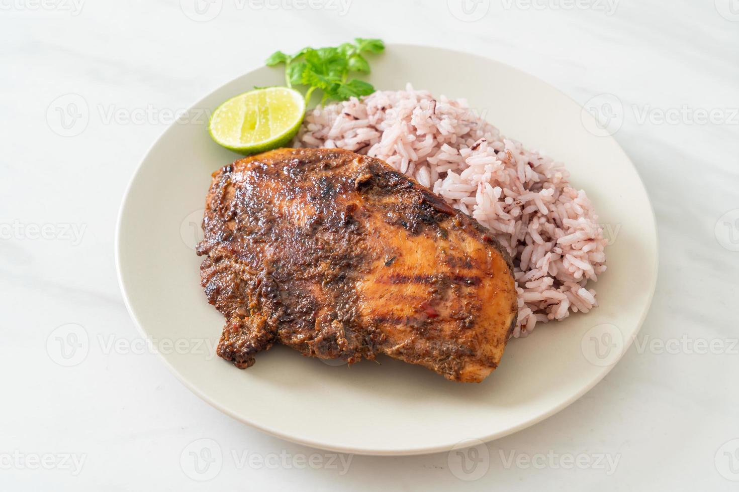 Pollo Jerk jamaicano picante a la parrilla con arroz - estilo de comida jamaicana foto