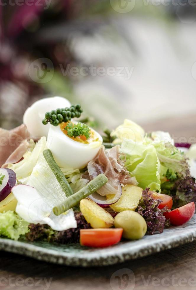 Ensalada rústica orgánica saludable estilo nicoise con huevo y jamón al aire libre foto