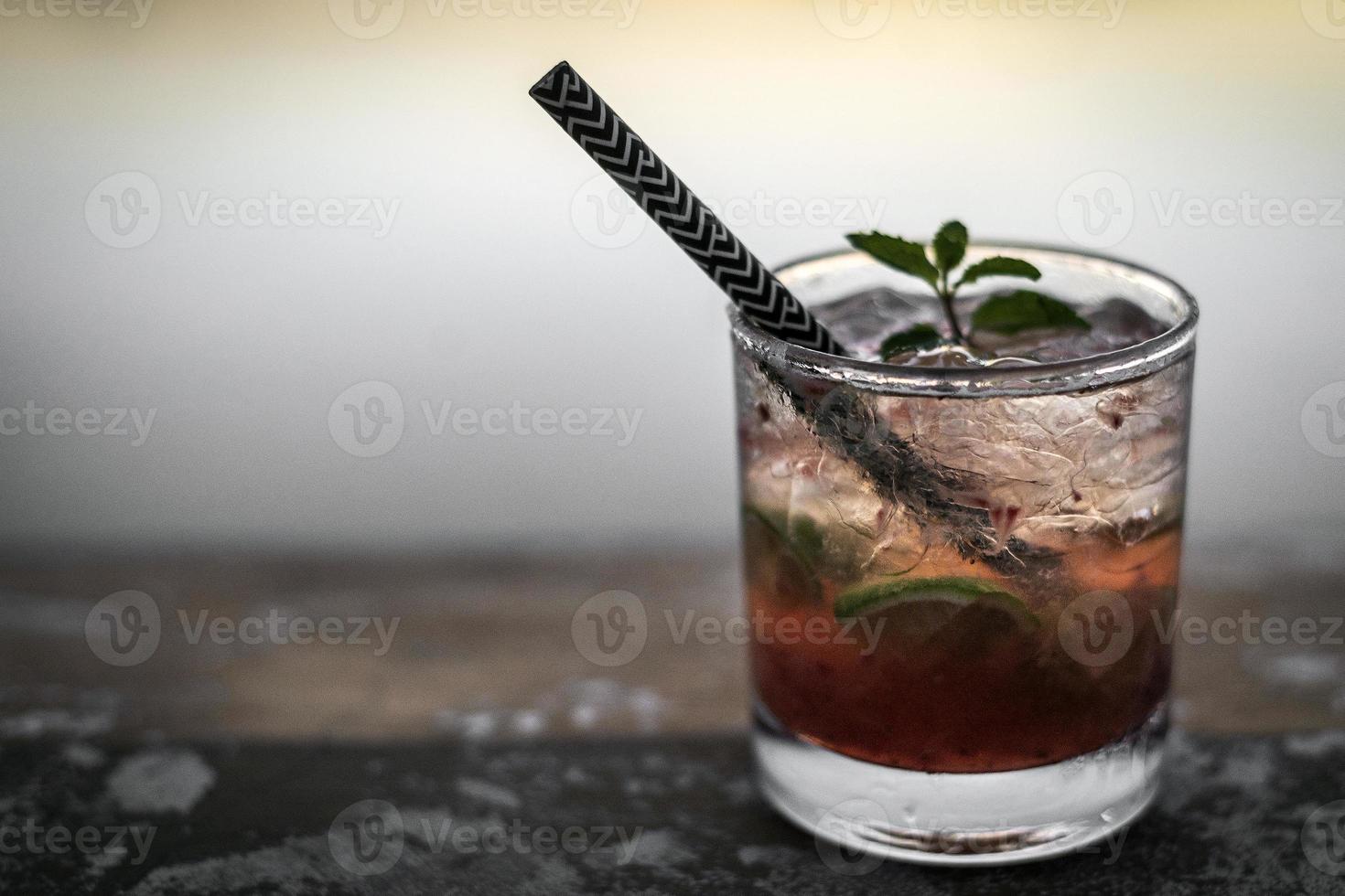 Strawberry caipirinha mixed cocktail drink in riverside Vientiane Laos outdoor bar at sunset photo