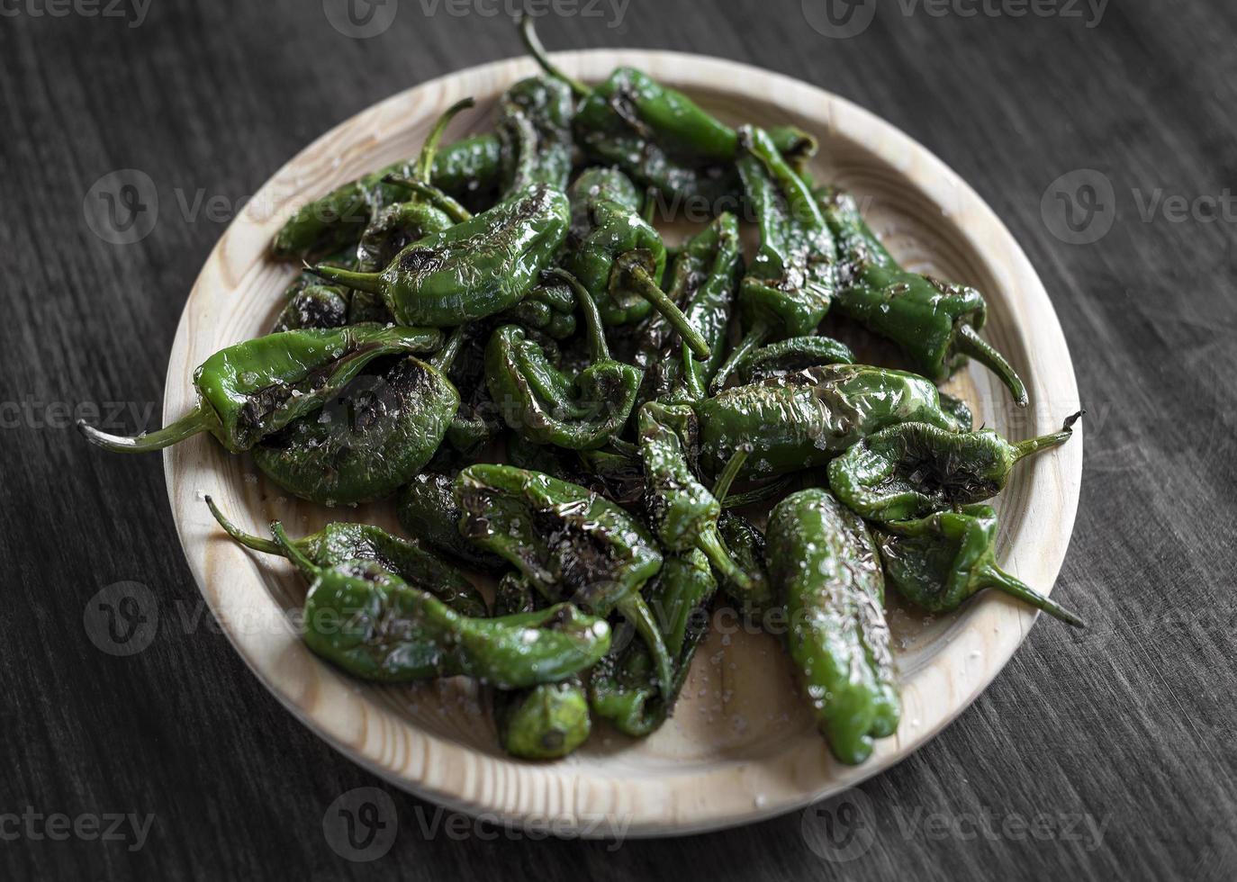 Pimientos Padrón español a la parrilla pimientos verdes tapas snack en la placa en el rústico restaurante de Santiago de Compostela foto