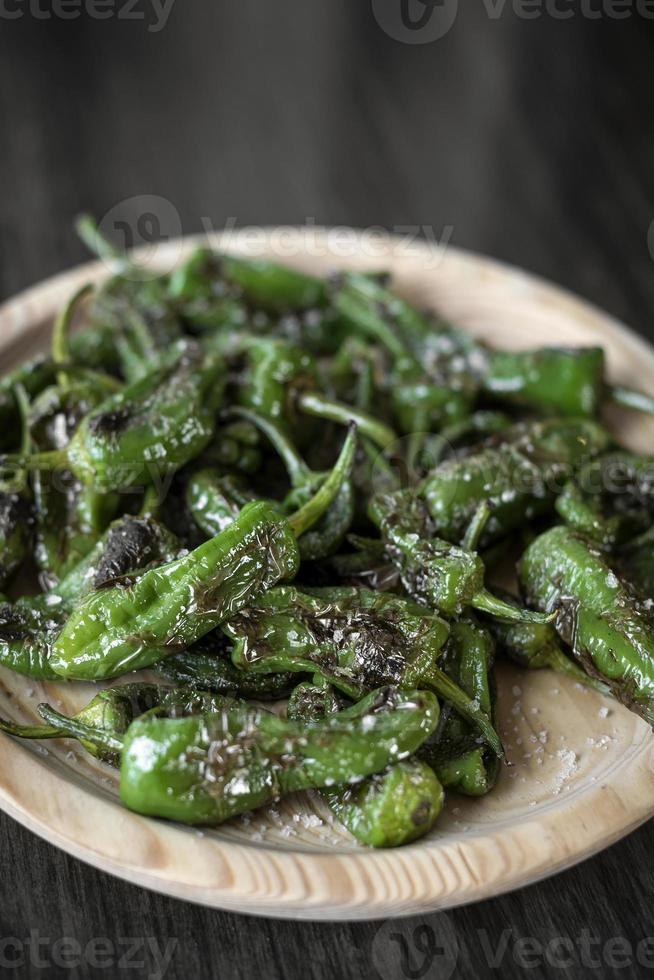 Pimientos Padron grilled Spanish green chili peppers tapas snack on plate in rustic Santiago de Compostela restaurant photo