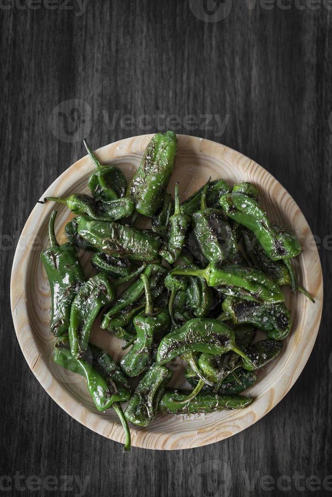 Pimientos Padrón español a la parrilla pimientos verdes tapas snack en la placa en el rústico restaurante de Santiago de Compostela foto