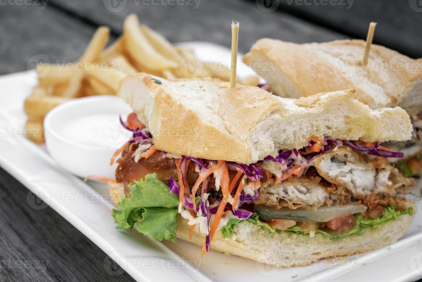 Fried battered fresh fish fillet sandwich with coleslaw salad french fries and tartar sauce photo