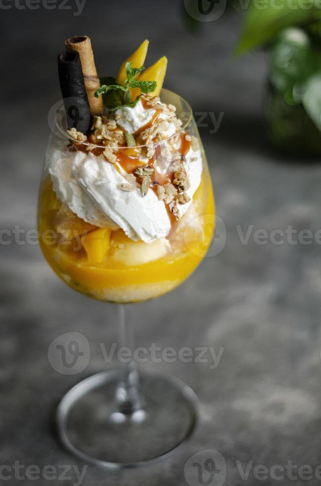 Sundae de helado tropical de mango orgánico y maracuyá en copa de vino foto