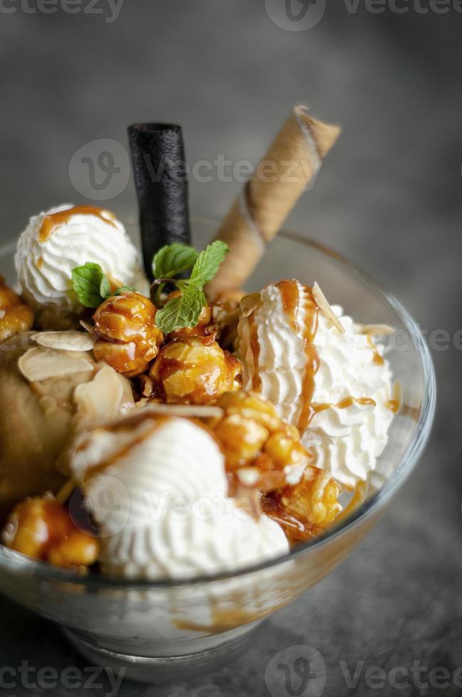 helado de caramelo y almendras con postre helado de palomitas de maíz caramelizadas en un tazón de vidrio foto