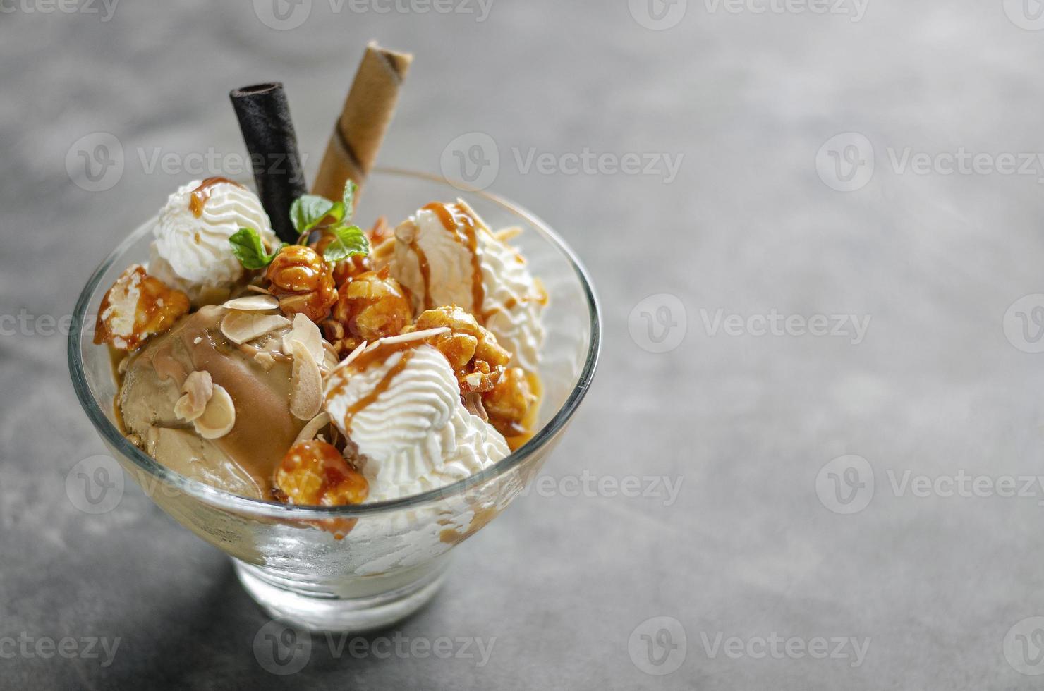 Caramel and almond ice cream with caramelized popcorn sundae dessert in glass bowl photo