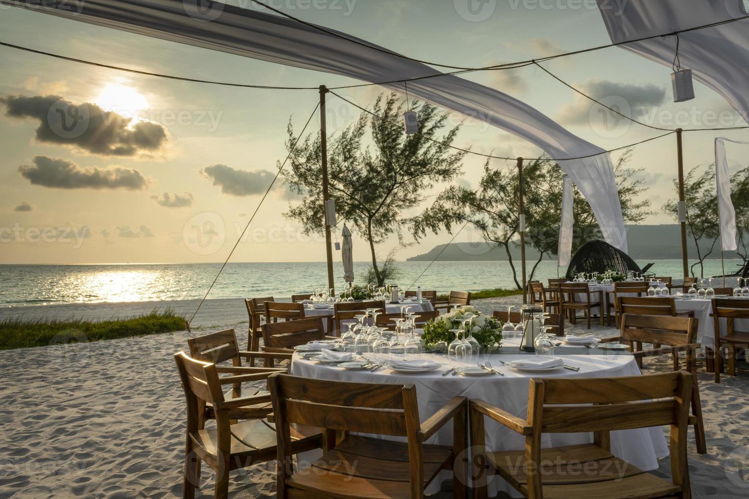 Diseño de mesa de boda romántica al atardecer afuera en la playa tropical asiática en Bali, Indonesia foto