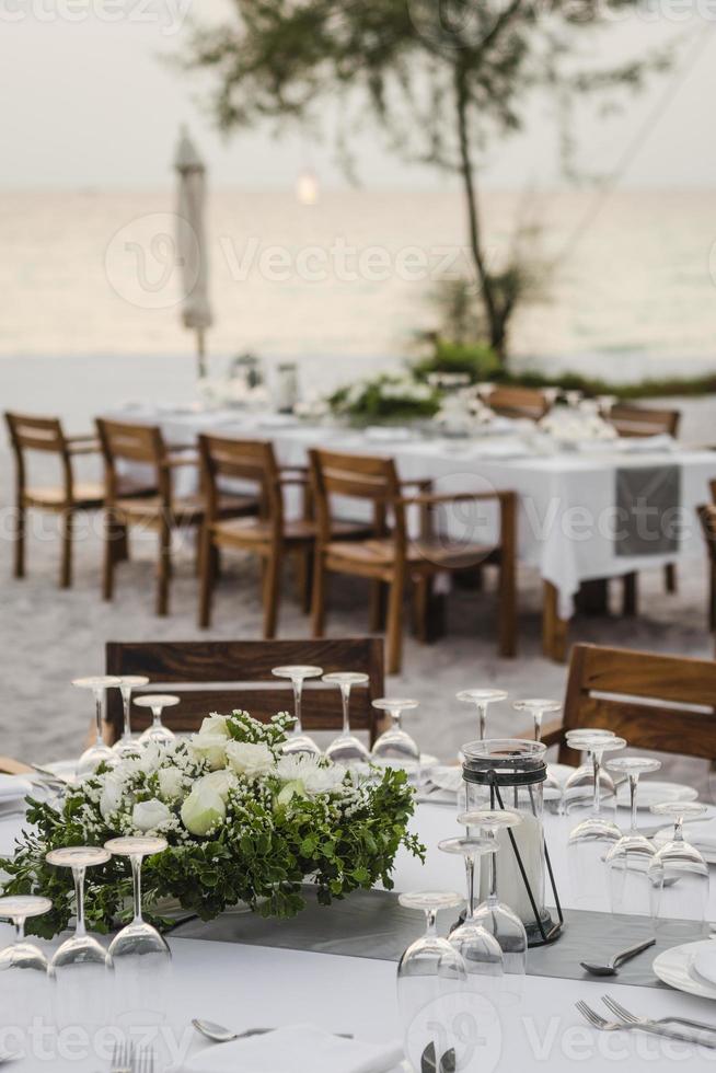 Diseño de mesa de boda romántica al atardecer afuera en la playa tropical asiática en Bali, Indonesia foto