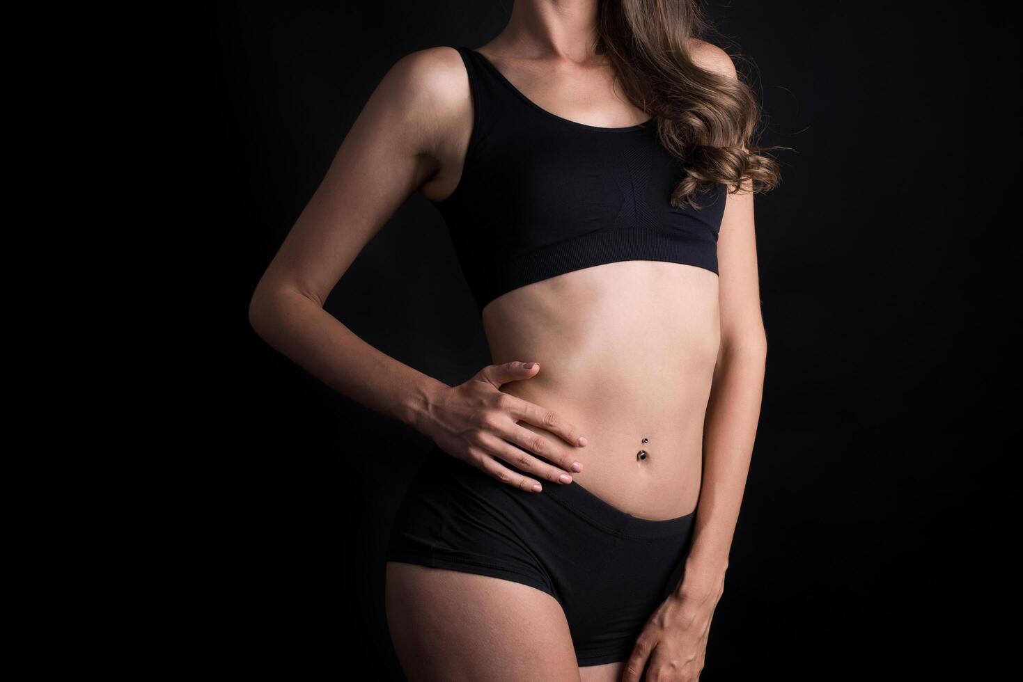 Beautiful woman with healthy body on black background photo