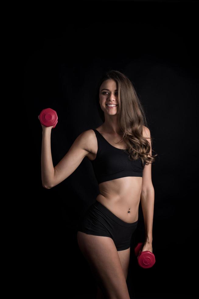 Young beautiful woman making physical exercises with dumbbells. photo