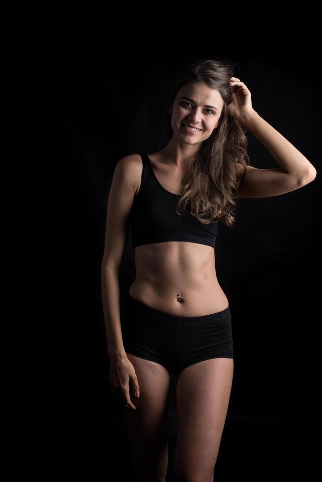 Beautiful woman with healthy body on black background photo