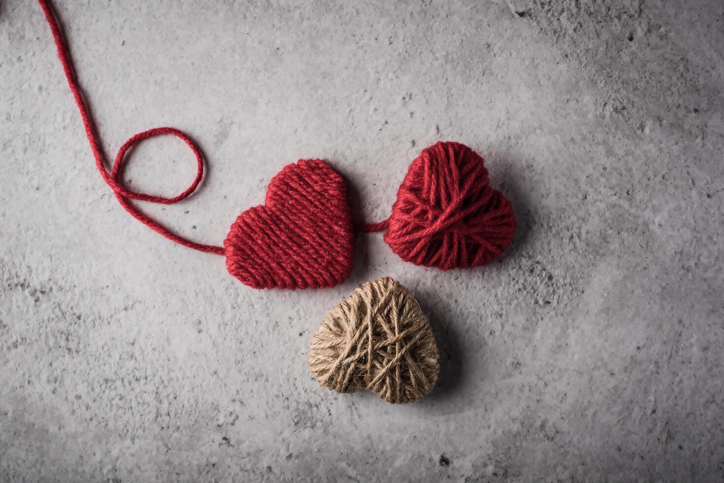 Red yarn heart shaped on the wall background. photo