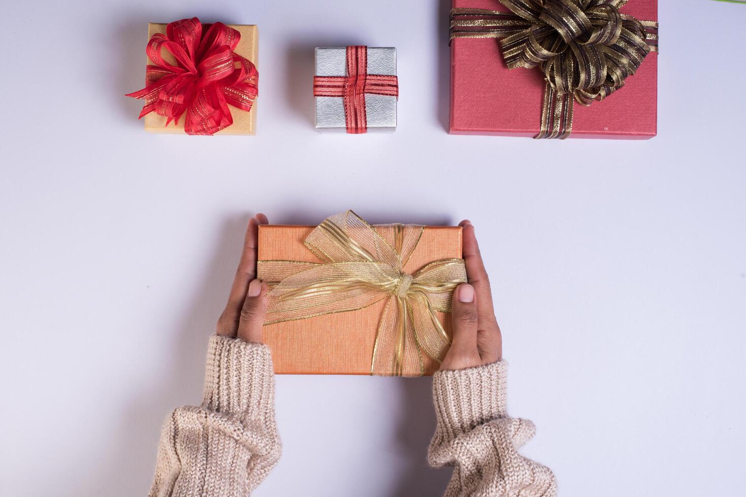 Top view Hand holding gift box on work space. photo