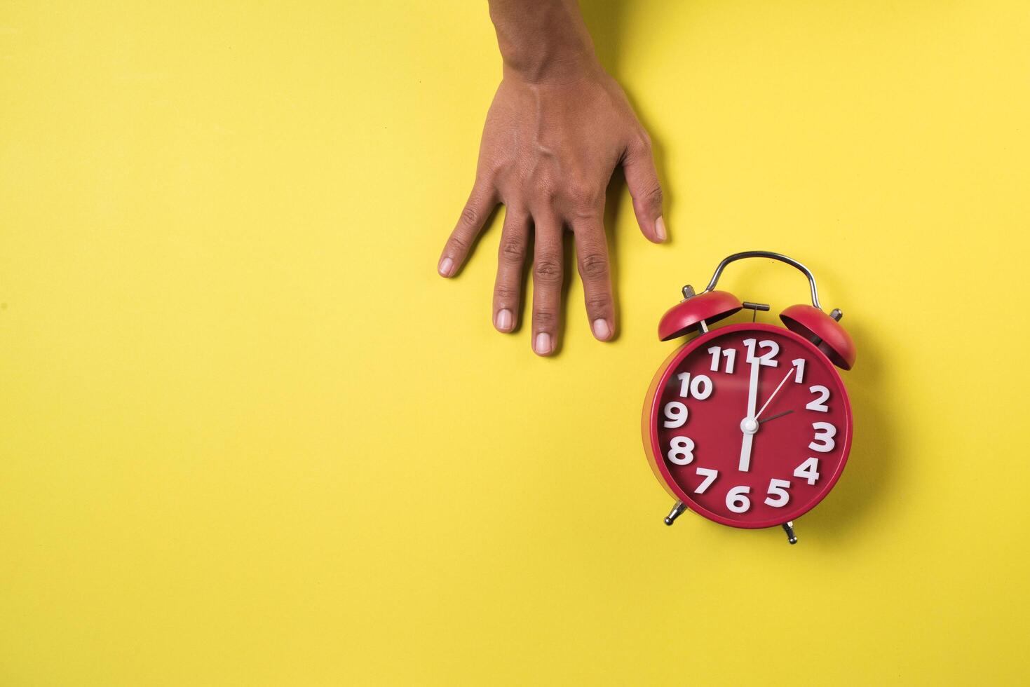 Top view hand and alarm clock. photo