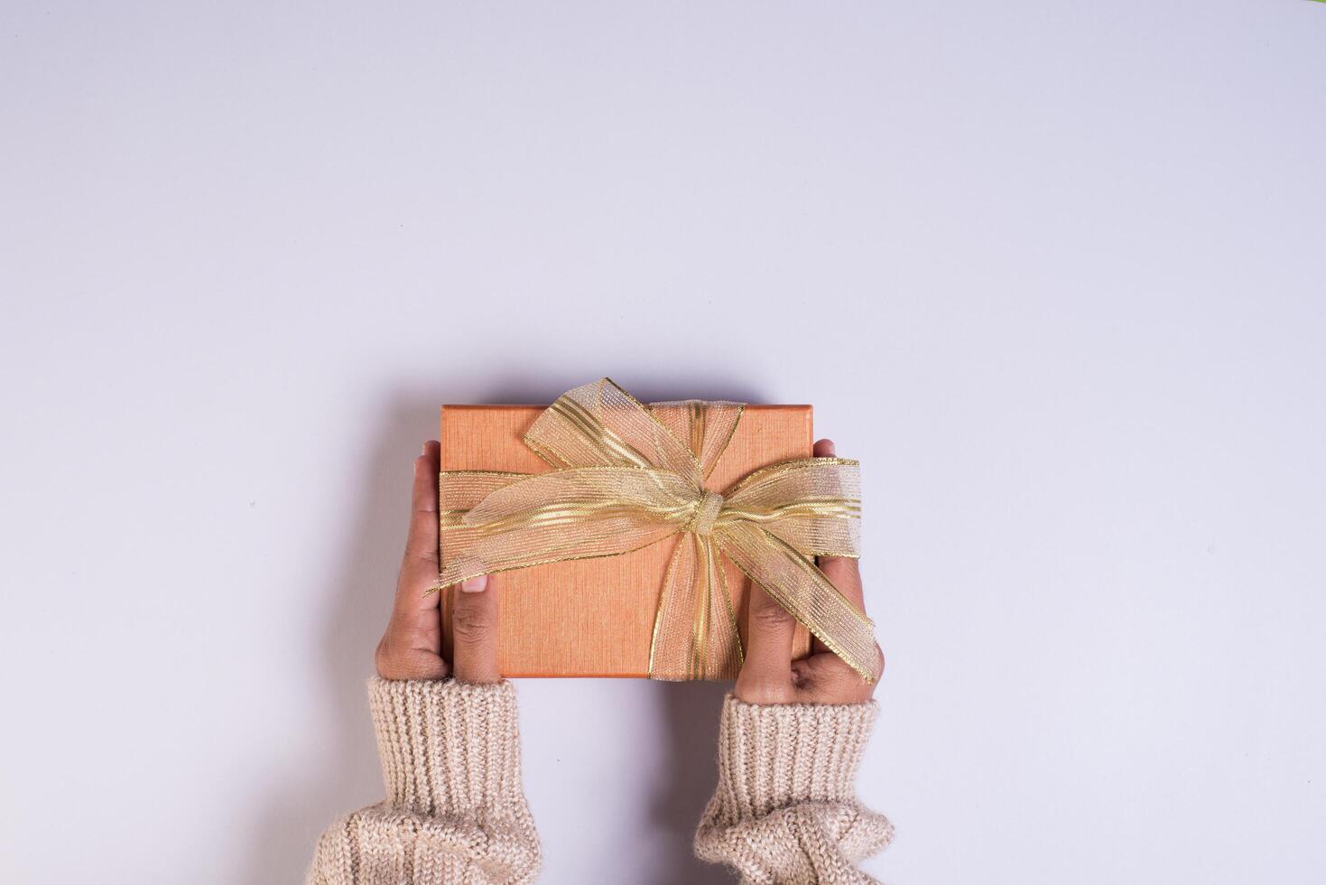 Top view Hand holding gift box on work space. photo